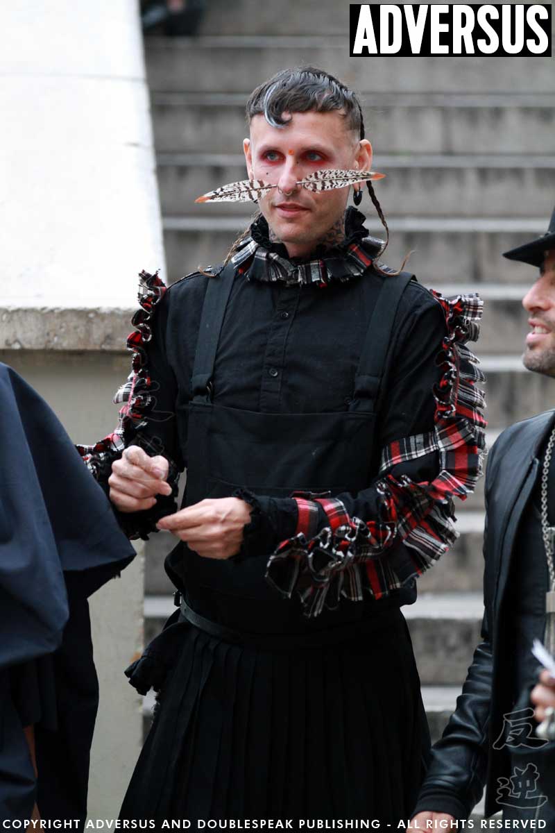 Street style uomo a Parigi. Penna d'uccello che trafigge il naso e gonnellona nera